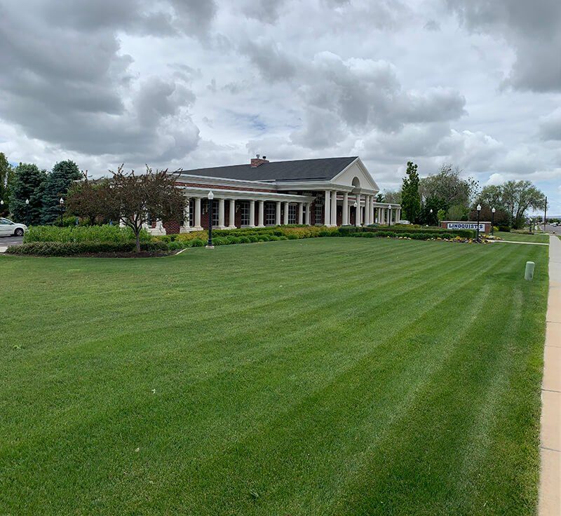 A large house with a lush green lawn in front of it.
