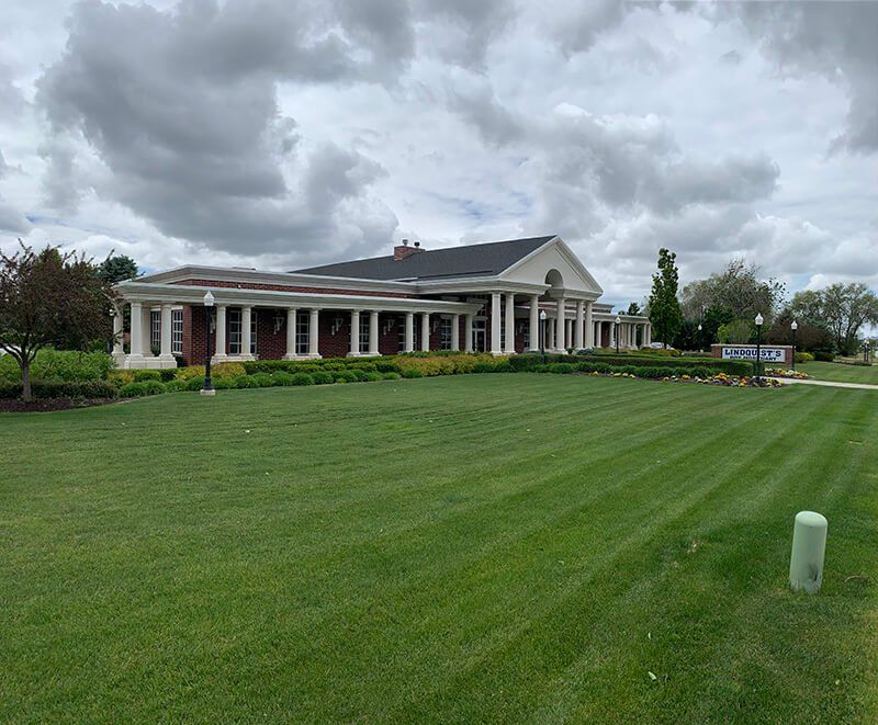 A large white house with a large lawn in front of it.