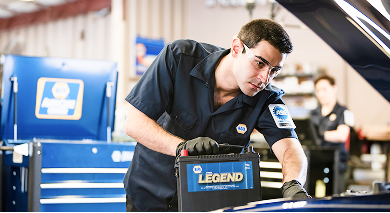 Mechanic replacing a car battery in a NAPA auto shop. | AAA Full Service Auto Care