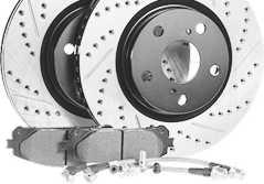 Two slotted and drilled brake rotors with brake pads and brake lines. | AAA Full Service Auto Care