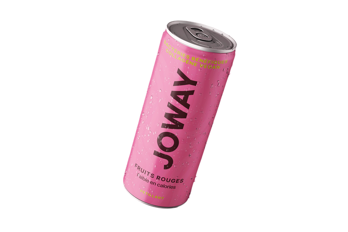 Une canette rose de boisson énergisante Joway, recouverte de condensation, est inclinée sur un fond blanc.