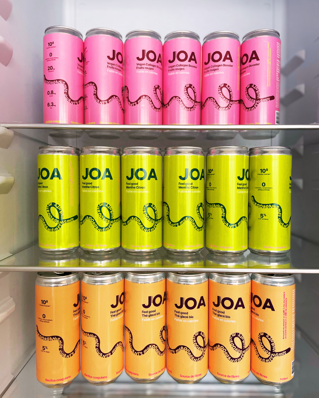 Trois canettes JOA de saveurs différentes empilées.