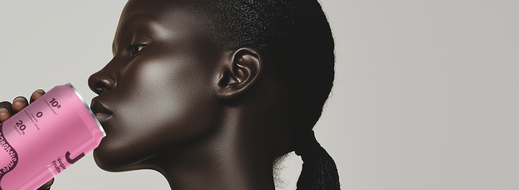 Une femme boit dans une canette rose.