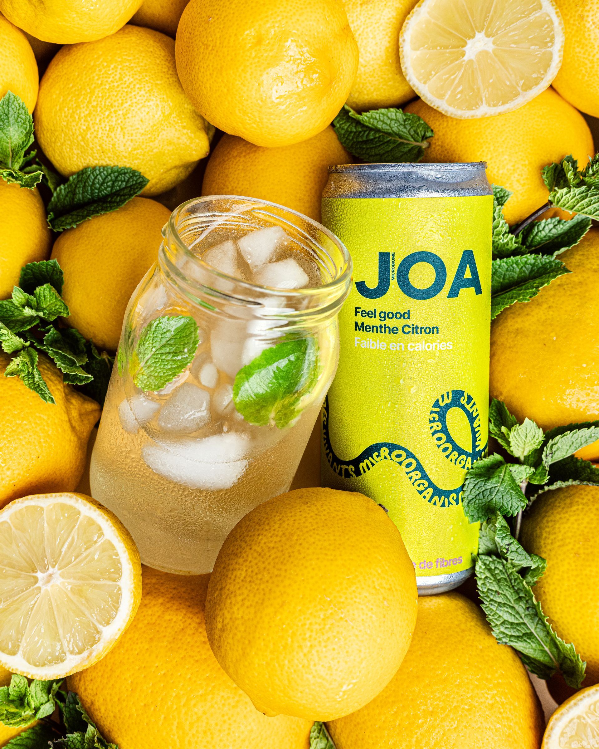 Une canette de joa est posée sur une surface jaune.