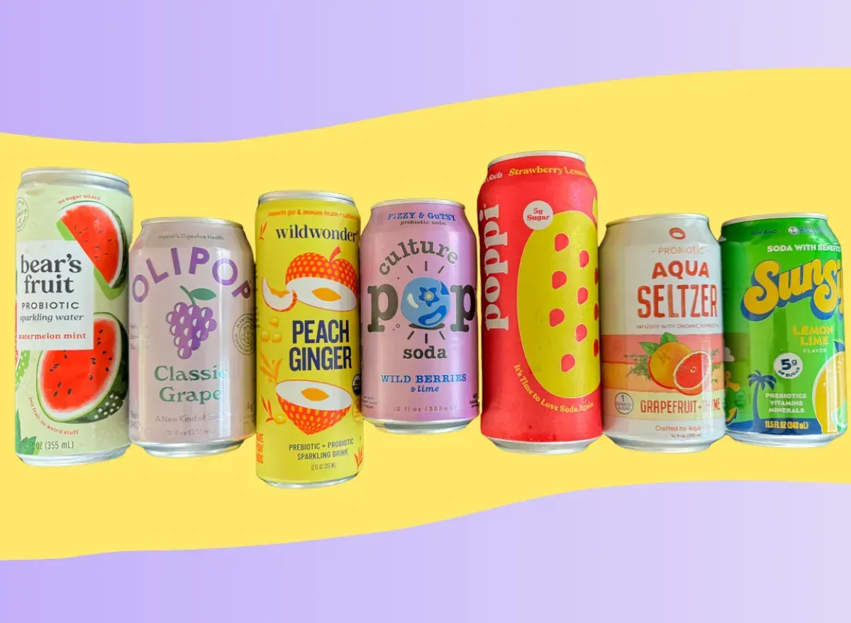 Assorted colorful cans of seltzer and sparkling water, lined up on a yellow and purple background.
