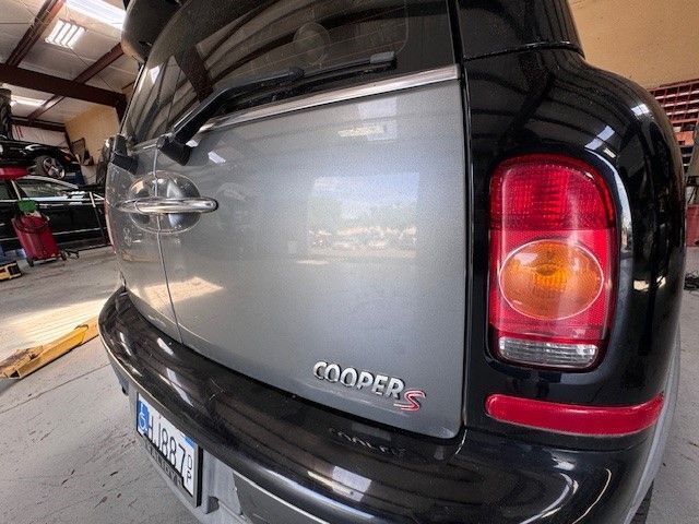 A silver mini cooper is parked in a garage.