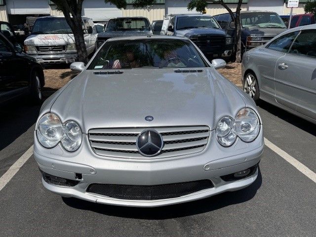 A silver mercedes is parked in a parking lot