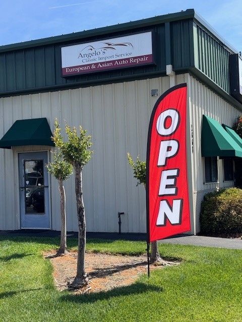 A red open flag is in front of a building