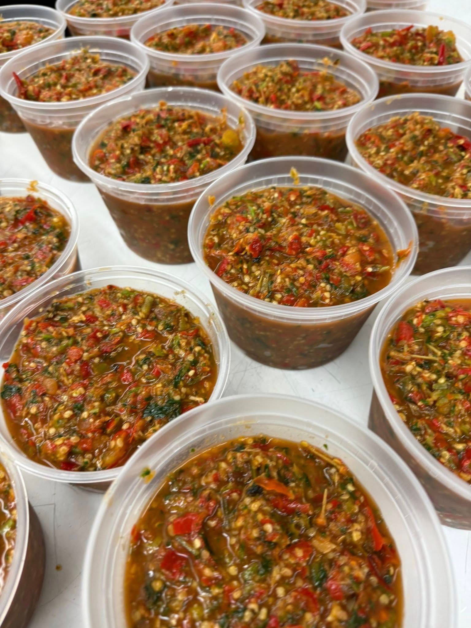 Containers of spicy relish with red and green peppers.