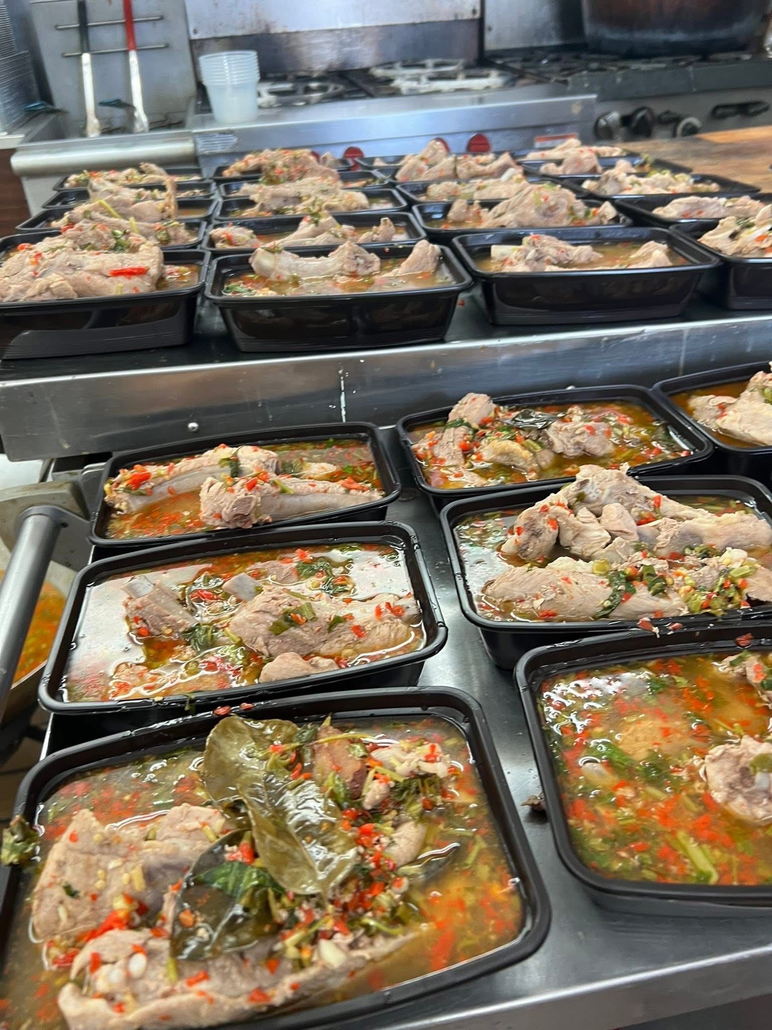 Prepared food containers filled with stew on a kitchen counter.