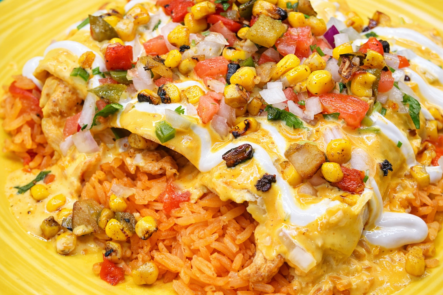 Mexican rice topped with cheesy enchiladas, sour cream, salsa, and corn