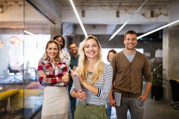 a group of people are standing next to each other in an office .