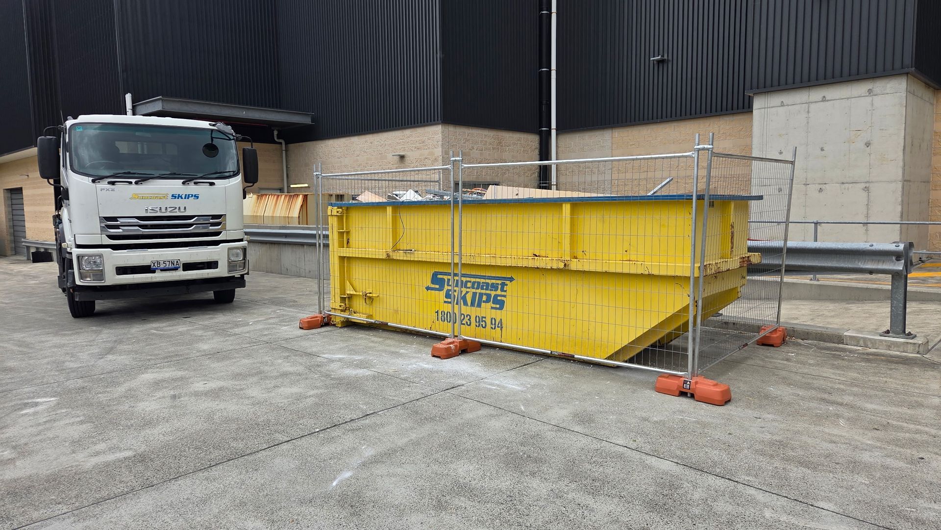 A Yellow Dumpster is in Front of a House Under Construction — Suncoast Skips in Coolum Beach, QLD