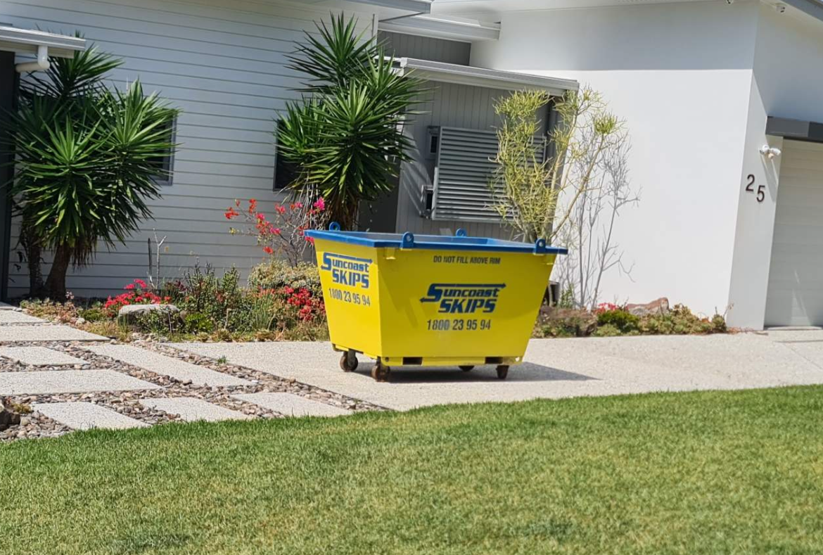 A yellow skip bin next to a house — Suncoast Skips in Coolum Beach, QLD