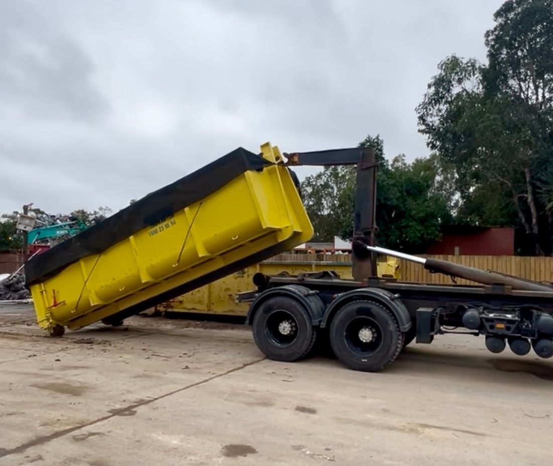 Large yellow hook bin being pulled by a truck — Suncoast Skips in Coolum Beach, QLD