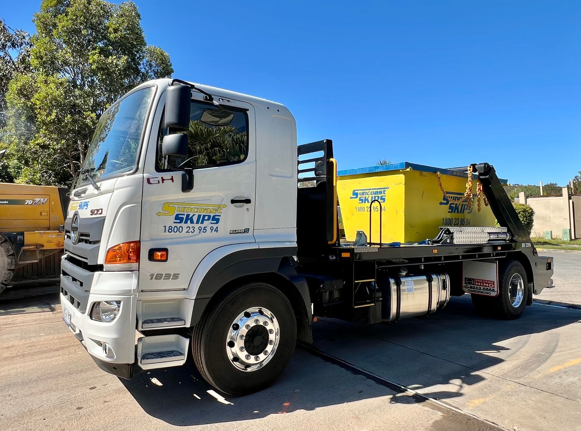 A truck is carrying a large yellow skip bin— Suncoast Skips in Coolum Beach, QLD