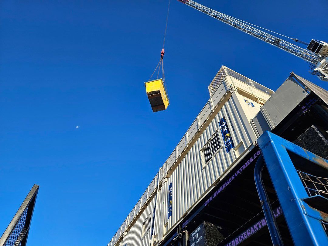 A Crane is Lifting a Yellow skip bin Into the Air — Suncoast Skips in Coolum Beach, QLD