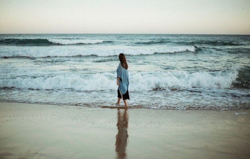 Woman Sitting On A Bed Stretching Her Arms — Vedic Meditation & Coherence Personal Counselling in Port Macquarie, NSW