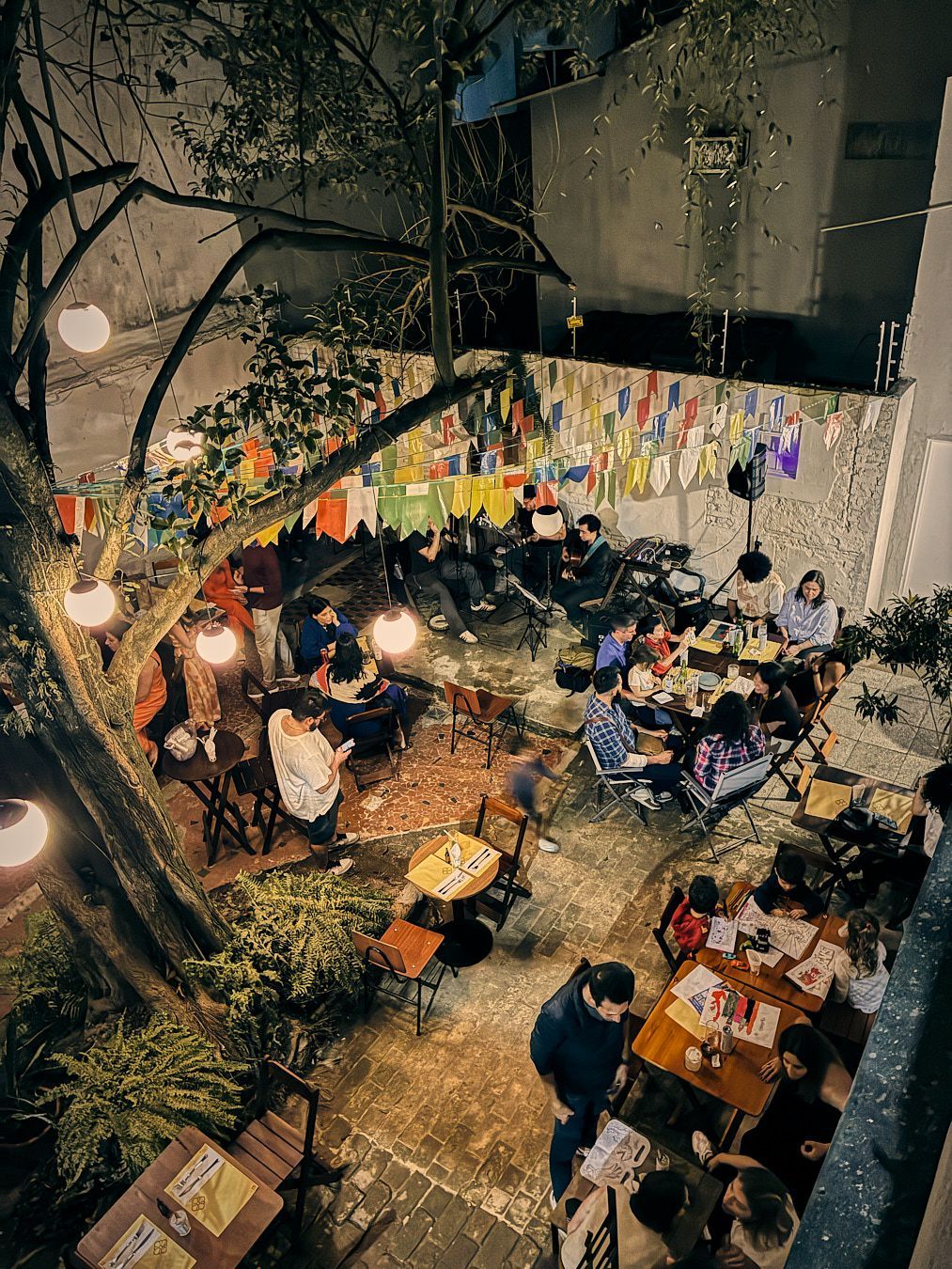 Um homem está tocando violão e cantando em um microfone no palco.