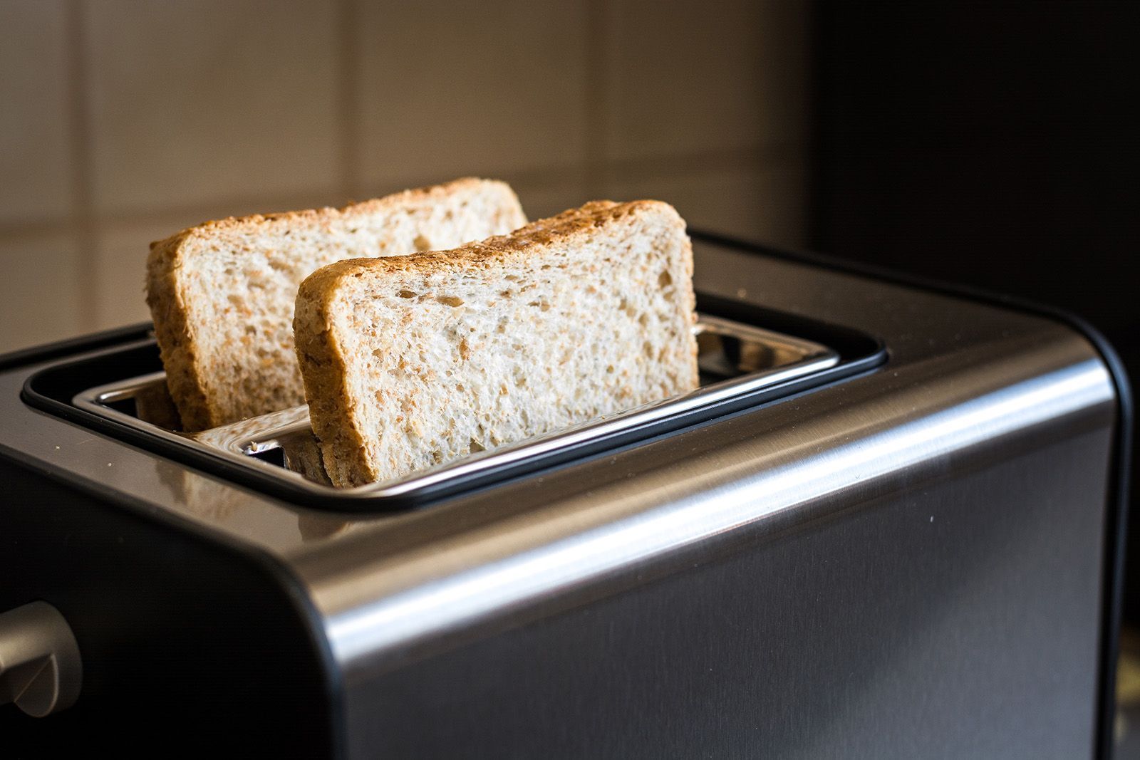 Dos rebanadas de pan tostándose en una tostadora negra y plateada.