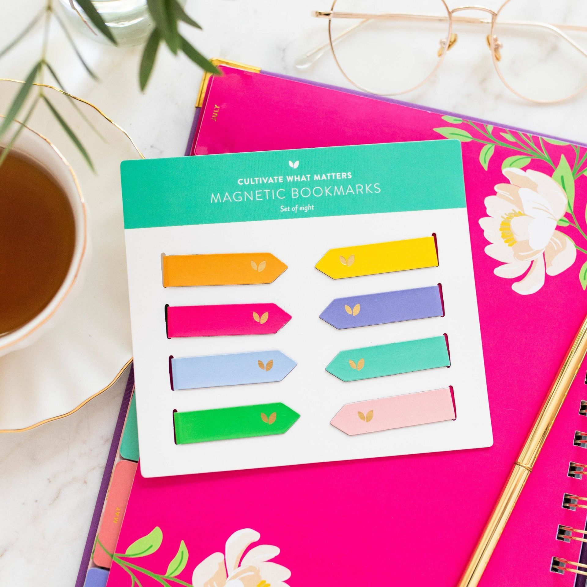 A set of magnetic bookmarks sitting on top of a pink notebook