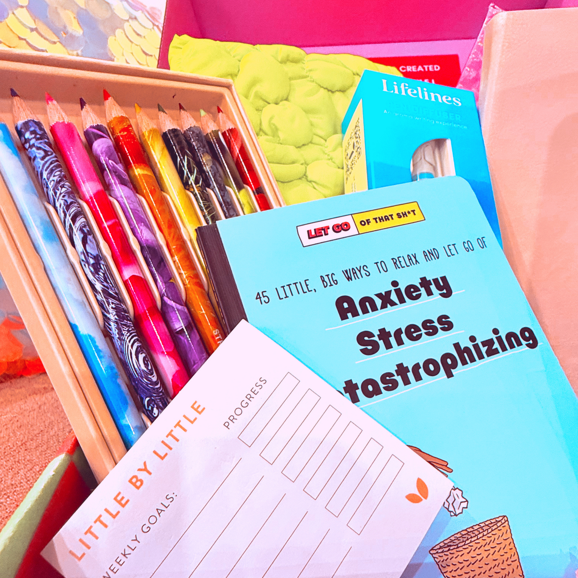 A box of colored pencils and a book called little by little