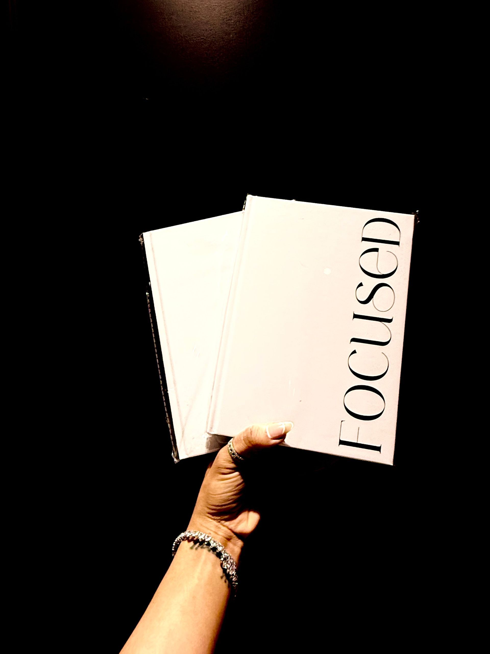 A person is holding a book titled focused in their hand.
