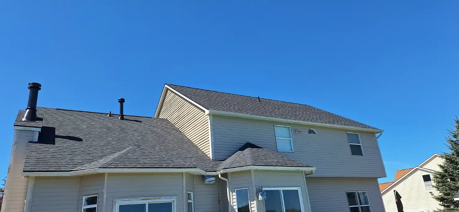 A large house with a roof that has been damaged by a storm.