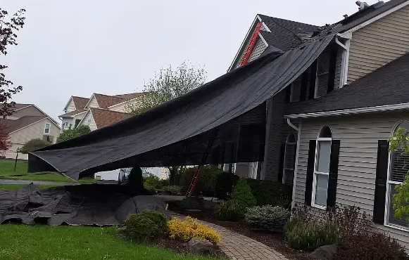 A side view of a roof installation, and the way we protect landscaping at 2 Guys