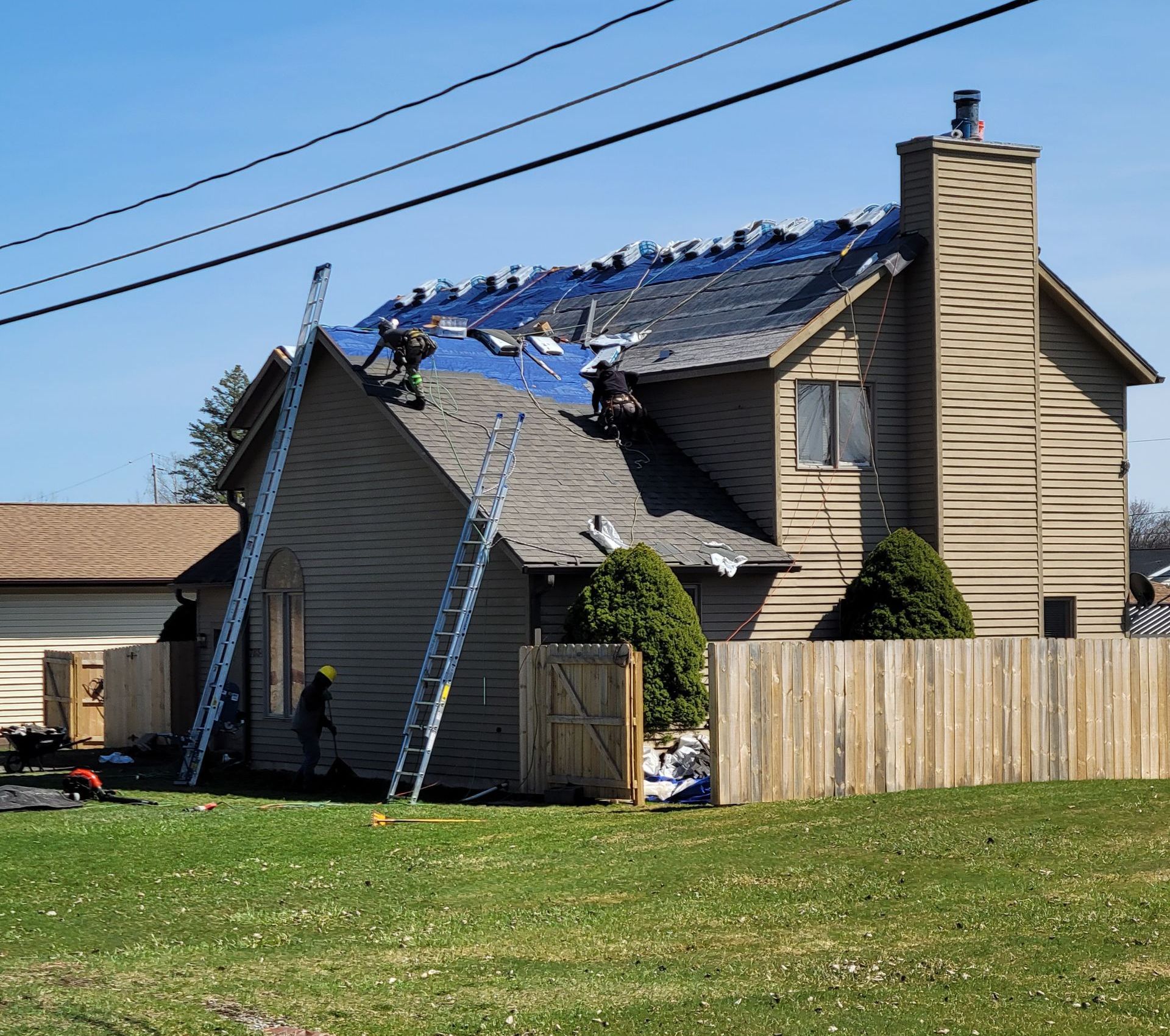 A group of construction workers are working on a roof.