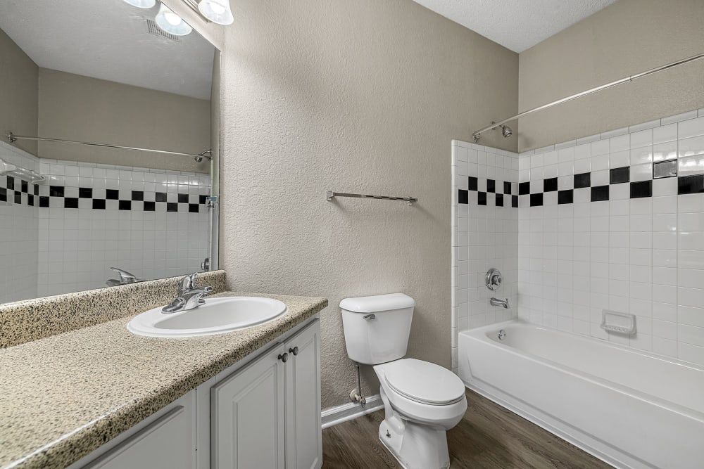 a bathroom with a toilet, sink, and bathtub at Marquis Midtown West in Atlanta, GA.