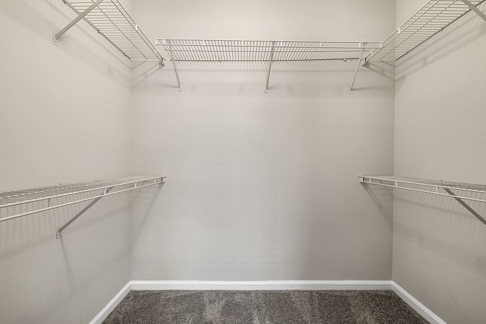 an empty walk-in closet with metal shelves and a carpeted floor at Marquis Midtown West in Atlanta, GA.