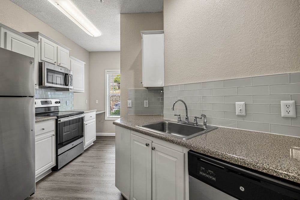 a kitchen with stainless steel appliances and granite counter tops at Marquis Midtown West in Atlanta, GA.
