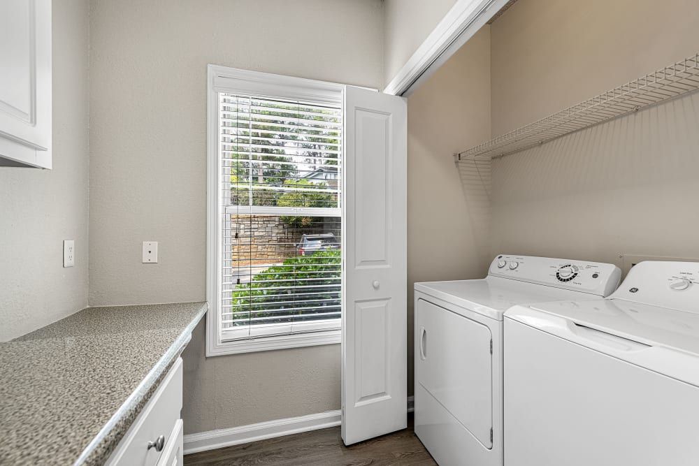 a laundry room with a washer and dryer and a window at Marquis Midtown West in Atlanta, GA.
