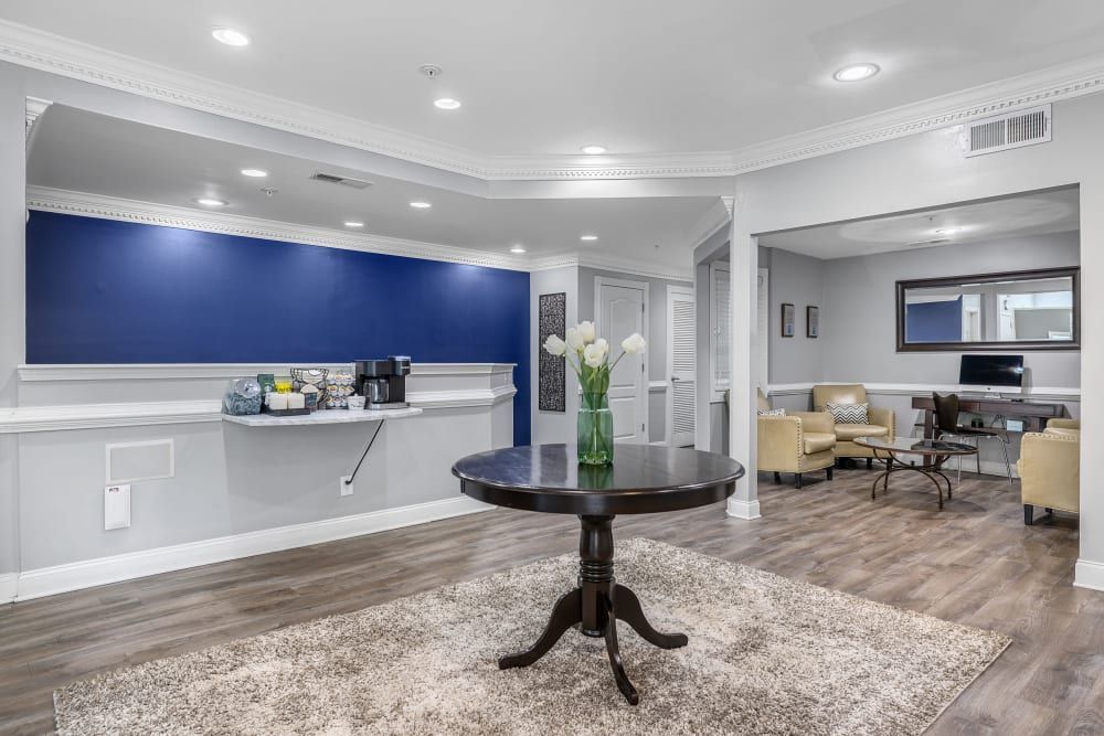 there is a table in the middle of the room with a vase of flowers on it at Marquis Midtown West in Atlanta, GA.