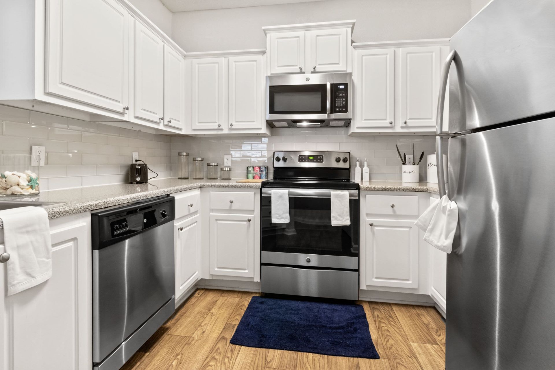 a kitchen with stainless steel appliances and white cabinets at Marquis Midtown West in Atlanta, GA.