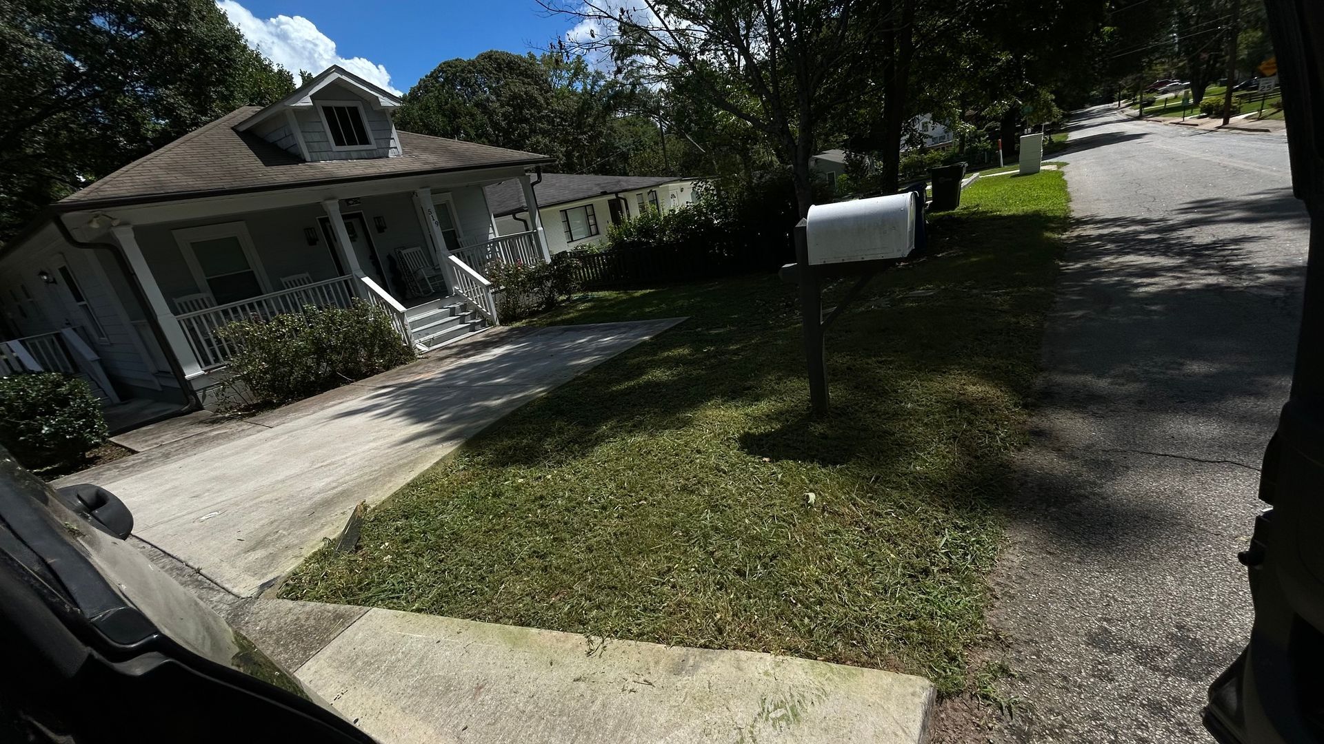 A suburban house with a driveway and mailbox on a sunny day.