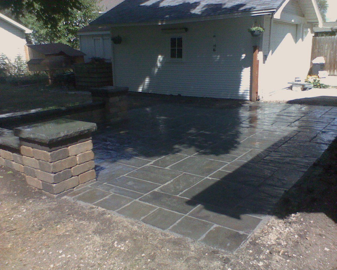 A white house with a brick patio in front of it