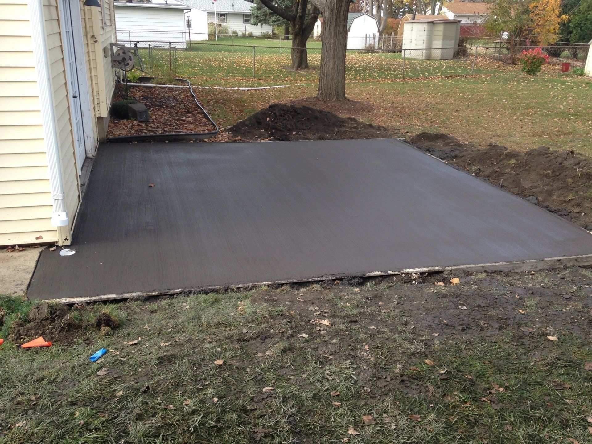 A concrete driveway is being built in front of a house.