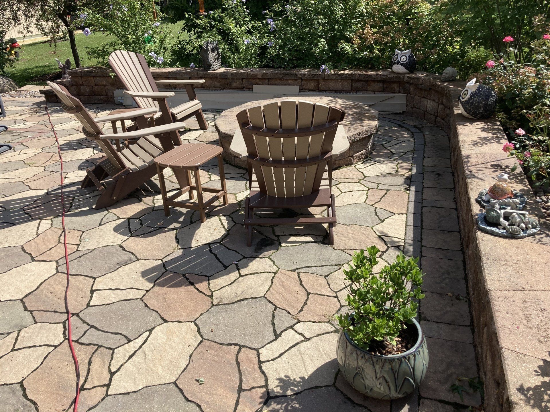 A patio with chairs , a table and a potted plant.