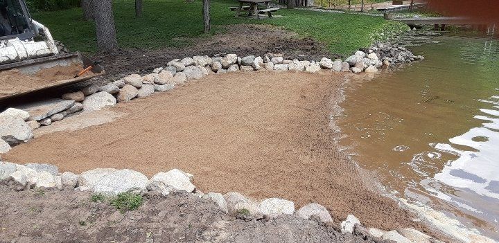 A large body of water is surrounded by rocks and dirt.
