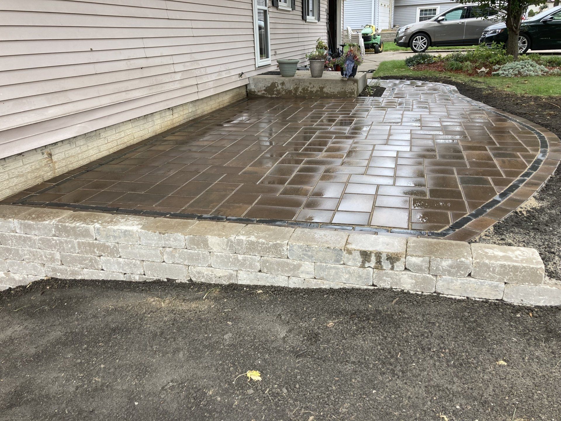 A brick walkway is being built in front of a house.