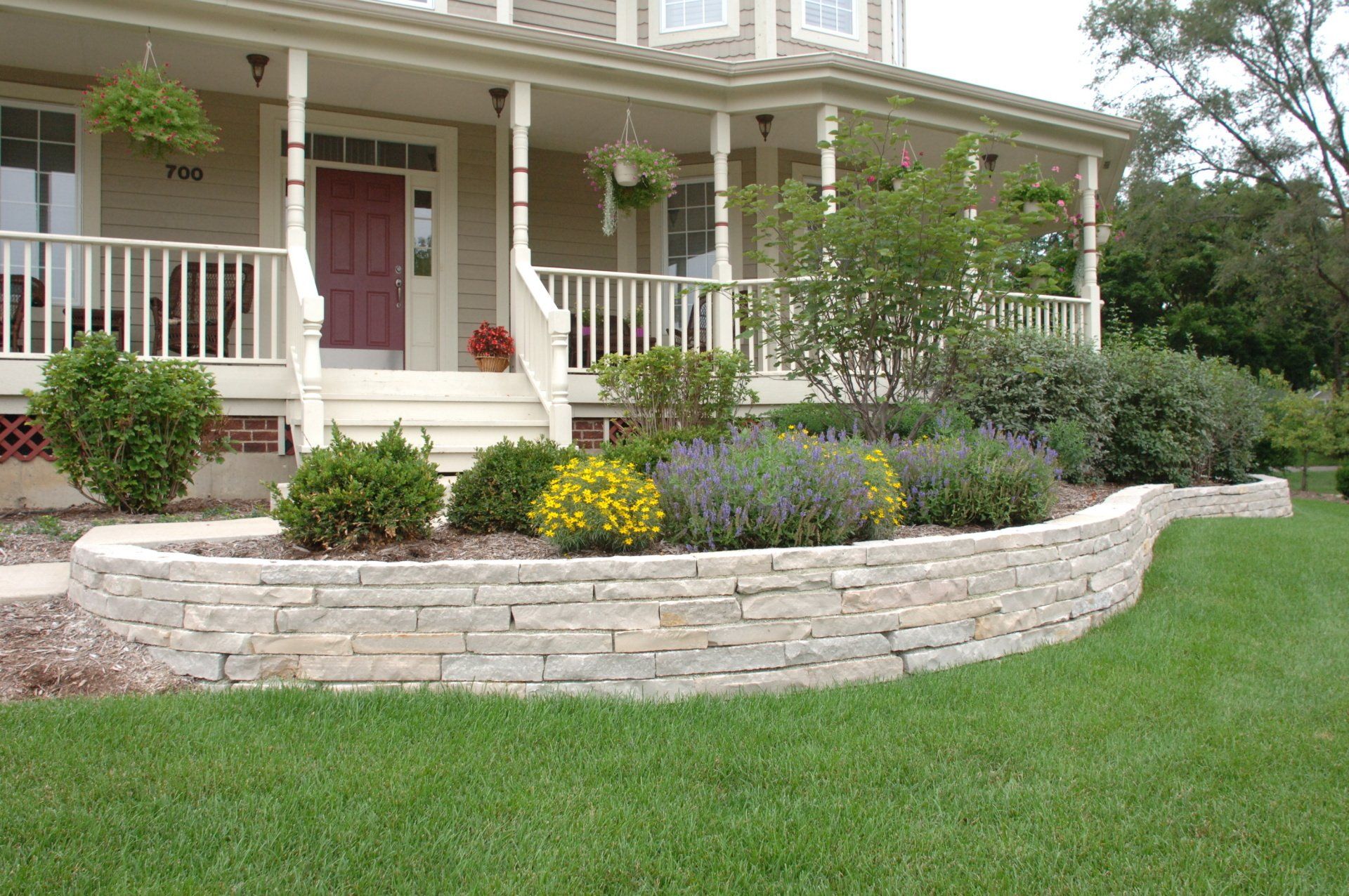 A house with a stone wall in front of it