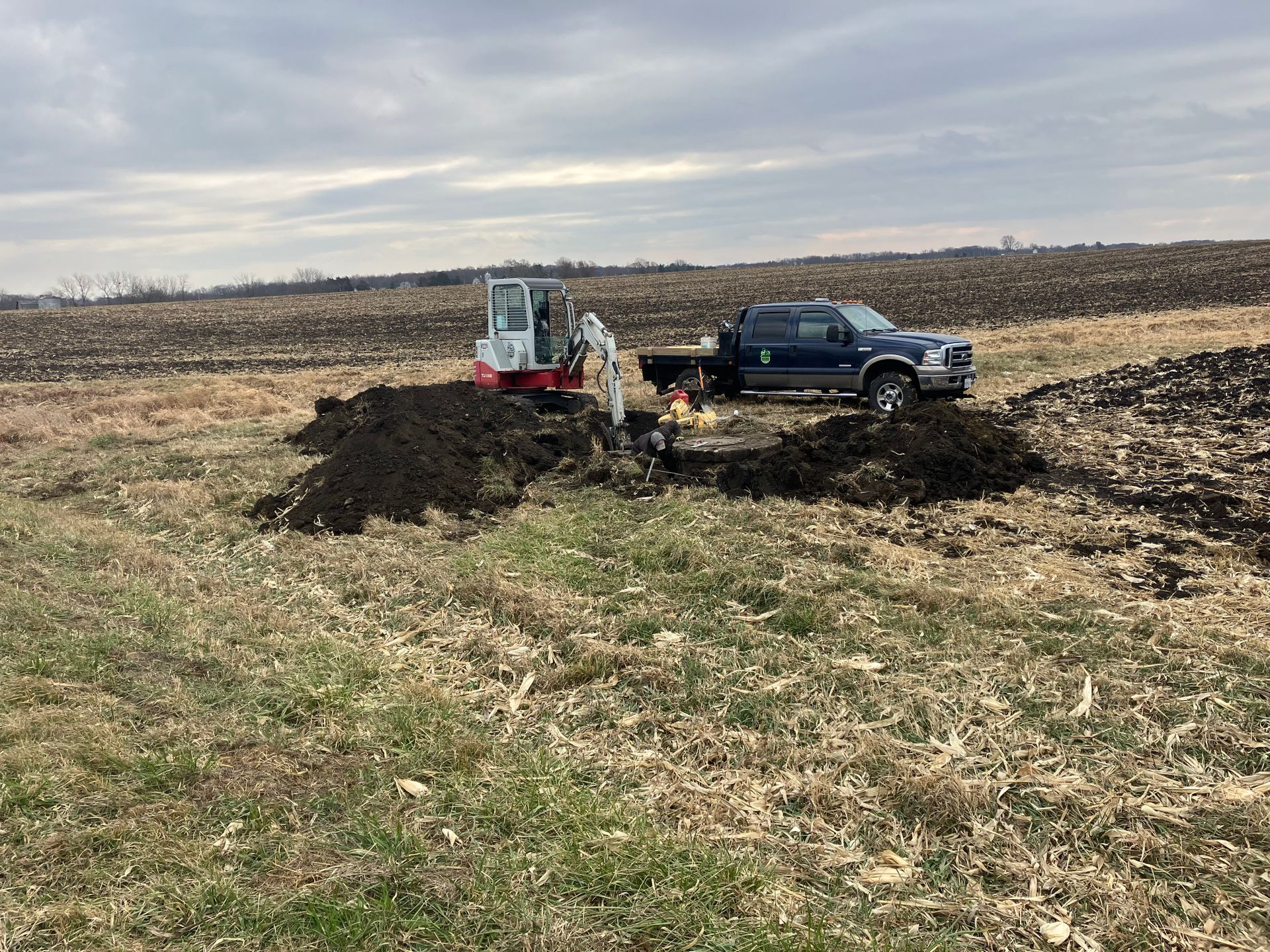 A truck is being towed by a bulldozer in a field.