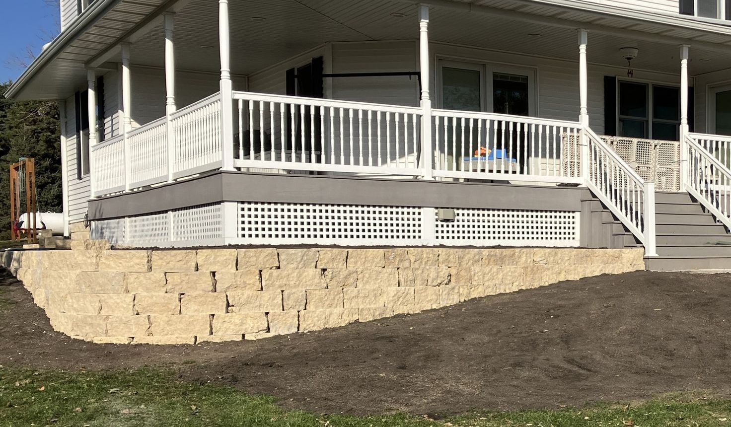 A large white house with a large porch and stairs.