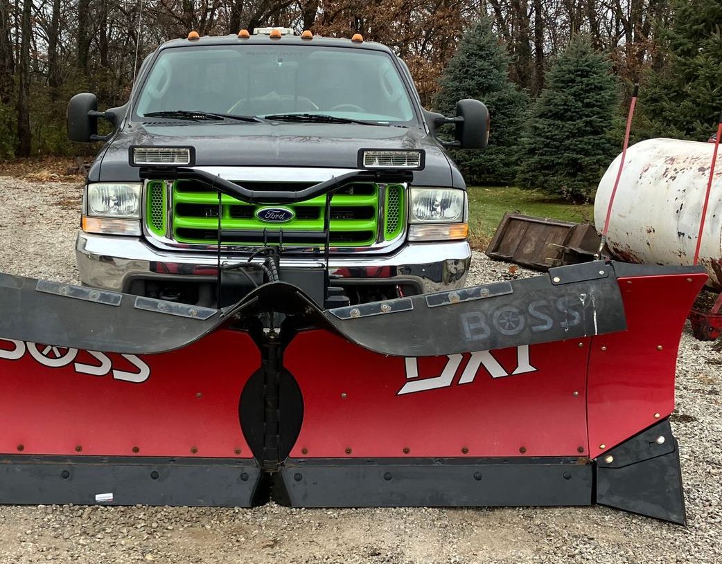 A ford truck with a snow plow attached to it