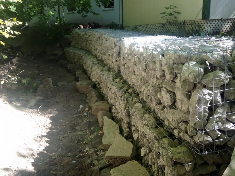 A stone wall with a wire fence surrounding it