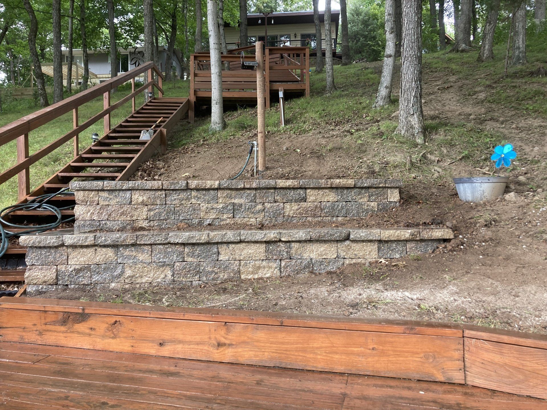 A wooden deck with stairs leading up to it and a house in the background.