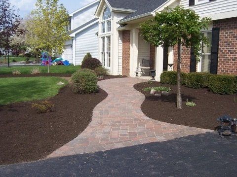 A brick walkway leading to a brick house