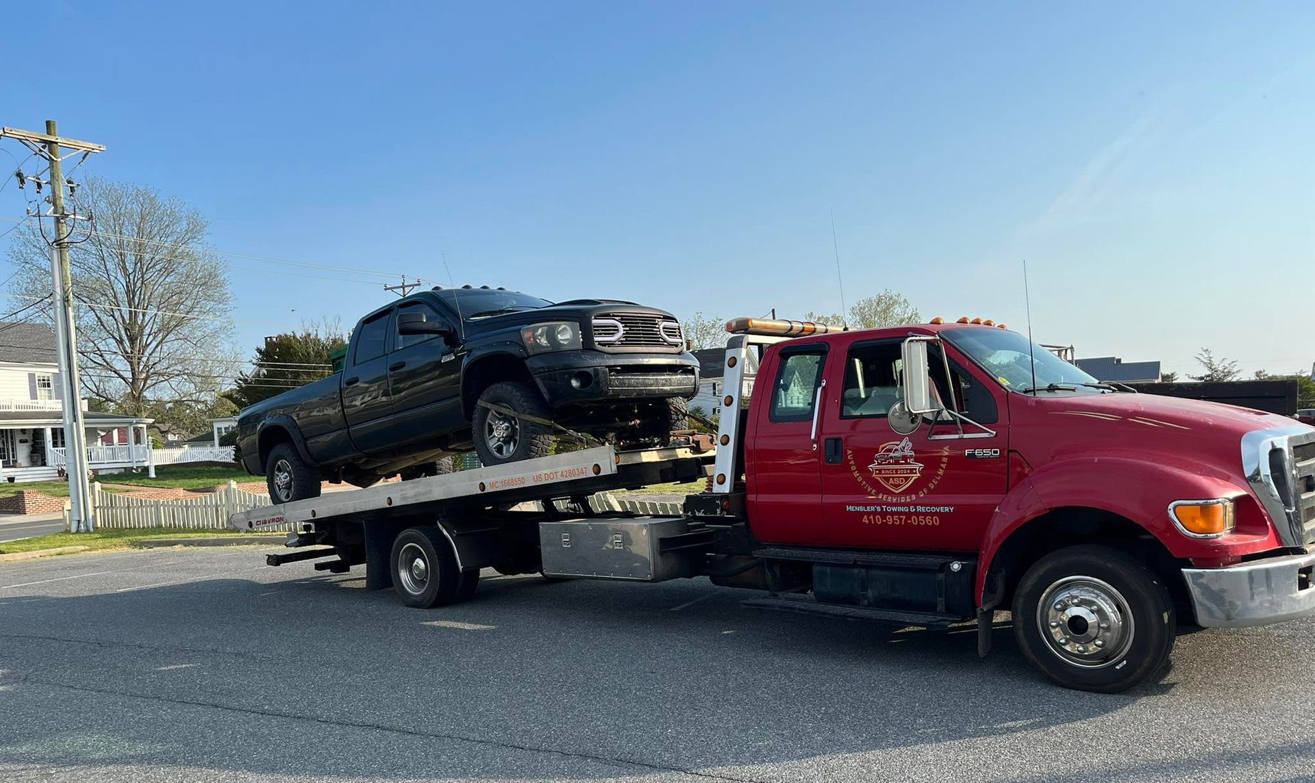Damaged gray Honda SUV with dented hood and cracked windshield, parked next to a brick building.